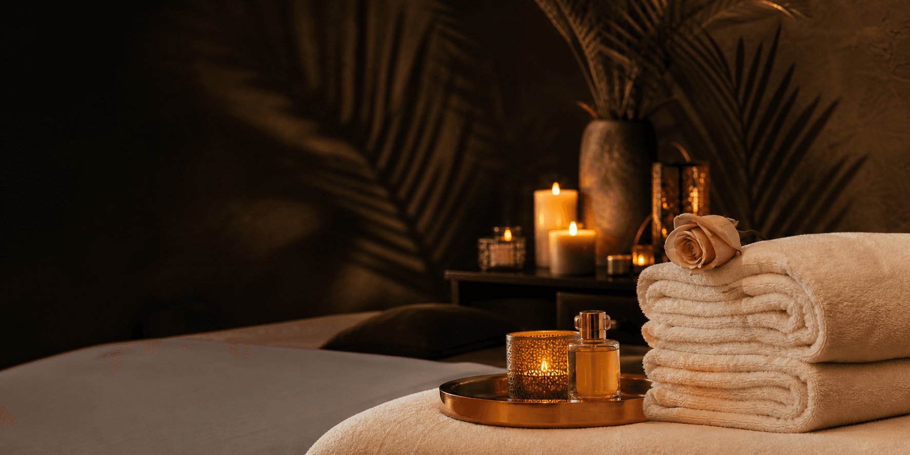 Ambiente privado de spa con velas, toallas y detalles dorados
